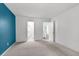 Bedroom with blue accent wall leading to an ensuite bathroom and hallway with stairs at 1136 Shadow Lake Cir, Mount Pleasant, SC 29464