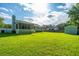 Spacious backyard featuring lush green grass, a screened porch and storage shed at 115 W Park Ln, Summerville, SC 29486