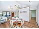 Bright dining area with modern chandelier, wood floors, and an open concept to the spacious living room at 115 W Park Ln, Summerville, SC 29486