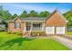 Lovely brick home features a covered porch, a two-car garage, and manicured landscaping at 115 W Park Ln, Summerville, SC 29486