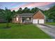 Charming brick home featuring a well-manicured lawn and an attached two-car garage at 115 W Park Ln, Summerville, SC 29486