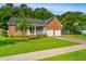 Beautiful front yard featuring a brick house with a two-car garage and mature shade trees at 115 W Park Ln, Summerville, SC 29486