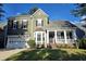 Charming two-story home features a front porch, attached garage, and beautiful landscaping at 116 Marshside Dr, Summerville, SC 29485
