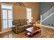 Cozy living room with hardwood floors, large windows, and an open staircase creates an inviting atmosphere at 116 Marshside Dr, Summerville, SC 29485