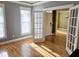 Open living room with hardwood floors, french doors, and large windows allowing for an abundance of light at 116 Marshside Dr, Summerville, SC 29485