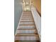 A staircase with carpet treads and a white banister leads to the next level at 116 Marshside Dr, Summerville, SC 29485