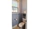 A functional bathroom with a toilet, floating shelf, and a window providing natural light at 116 Marshside Dr, Summerville, SC 29485