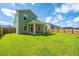 Large backyard with green grass, wood fence, and covered patio at 119 Lucca Dr, Summerville, SC 29486