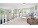 Upstairs loft featuring neutral carpet, wood trim, a railing overlooking the pool, and abundant natural light at 119 Lucca Dr, Summerville, SC 29486