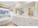 Bright primary bathroom featuring double vanity, a large mirror, and a soaking tub at 1226 Spotflower St, Summerville, SC 29485