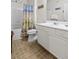 Well-lit bathroom featuring a shower with a beach-themed curtain, white vanity, and tile flooring at 1300 Park West Blvd # 106, Mount Pleasant, SC 29466