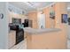 Modern kitchen with stainless steel appliances, black countertops, and a breakfast bar area at 1300 Park West Blvd # 106, Mount Pleasant, SC 29466