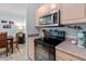 Kitchen with stainless steel microwave, stove, and cabinetry with view to dining area at 1300 Park West Blvd # 106, Mount Pleasant, SC 29466