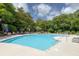 Community pool surrounded by lush greenery and lounge chairs, perfect for relaxation at 1300 Park West Blvd # 106, Mount Pleasant, SC 29466
