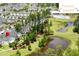 Aerial view of a residential community featuring a pool, dog park, pond, and lush greenery at 132 Clear Bend Ln, Summerville, SC 29486