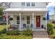 Inviting front porch featuring a swing, chairs, and charming decor, leading to a red front door at 132 Clear Bend Ln, Summerville, SC 29486