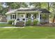 Exterior of a well-kept home with a welcoming front porch, brick stairs, lush lawn, and mature trees at 1337 Old Fort Rd, Moncks Corner, SC 29461