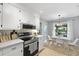 Modern kitchen showcasing stainless steel appliances, white cabinets, and a view into the cozy dining area at 1337 Old Fort Rd, Moncks Corner, SC 29461