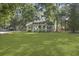 Expansive green lawn surrounds a cozy home, complemented by mature trees and lush greenery for serene outdoor living at 1337 Old Fort Rd, Moncks Corner, SC 29461