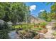 The fenced backyard features raised garden beds, mature plants, and a stone and gravel walking path at 1350 Water Edge Dr, Charleston, SC 29492
