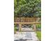A charming wooden garden gate leads to a garden with mature plants and stone pathway at 1350 Water Edge Dr, Charleston, SC 29492