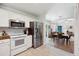 Modern kitchen features white cabinetry, stainless steel appliances, and an open view to dining and living areas at 1350 Water Edge Dr, Charleston, SC 29492