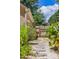 A landscaped side yard features mature plants, a stone path, and a wooden fence and gate at 1350 Water Edge Dr, Charleston, SC 29492
