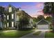 Charming two-story home with a covered porch, green exterior, and a well-manicured lawn at dusk at 136 Heart Pine Cir, Summerville, SC 29485