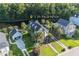 Green two-story home with a detached garage, surrounded by lush greenery and landscaping at 136 Heart Pine Cir, Summerville, SC 29485