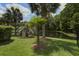 Green backyard with tropical trees and scenic water view, offering a tranquil and lush outdoor space at 136 Heart Pine Cir, Summerville, SC 29485