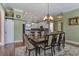 Well-lit dining room with a decorative chandelier, a spacious table, and view into the kitchen at 136 Heart Pine Cir, Summerville, SC 29485