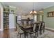 Charming dining room with sliding pantry door to left of table, decorative lighting, and view of modern kitchen at 136 Heart Pine Cir, Summerville, SC 29485