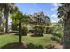 Lush backyard featuring a charming green home, a gazebo, and an abundance of tropical trees at 136 Heart Pine Cir, Summerville, SC 29485