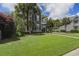 Beautifully landscaped front yard with lush green grass and mature trees surrounding a charming two-story home at 136 Heart Pine Cir, Summerville, SC 29485
