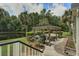 Relaxing patio with gazebo, plush seating, grill, and view of pond surrounded by verdant trees at 136 Heart Pine Cir, Summerville, SC 29485