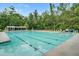 A well-maintained community swimming pool with lounge chairs, umbrellas, and lots of trees at 136 Heart Pine Cir, Summerville, SC 29485