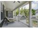 Covered porch with ceiling fans and lounge chairs overlooks the backyard and surrounding foliage at 136 Heart Pine Cir, Summerville, SC 29485