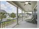 Relaxing covered porch with multiple ceiling fans and lounge chairs overlooks a neighborhood at 136 Heart Pine Cir, Summerville, SC 29485