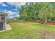 A spacious backyard with green grass, a red fence, and palm trees near the center at 139 Gaslight Blvd, Summerville, SC 29483
