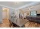 Open dining room with a large wooden table, modern lighting, and view to the living room at 139 Gaslight Blvd, Summerville, SC 29483