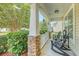 Relaxing front porch with stone-clad columns, rocking chairs, and serene outdoor view at 139 Gaslight Blvd, Summerville, SC 29483
