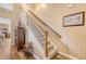 A staircase leading to the second floor, featuring wooden handrails, carpeted steps, and an adjacent cabinet at 139 Gaslight Blvd, Summerville, SC 29483