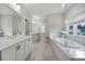 This is a bright bathroom with a soaking tub, large mirrors and plenty of storage at 1464 Stratton Pl, Mount Pleasant, SC 29466