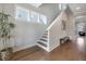 Bright hallway featuring hardwood floors, stairs to the second floor, and a decorative plant at 1464 Stratton Pl, Mount Pleasant, SC 29466