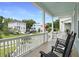 Relaxing front porch featuring rocking chairs and scenic neighborhood views under a blue sky at 1464 Stratton Pl, Mount Pleasant, SC 29466