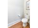 Powder room featuring a toilet, hardwood floors, and minimalist decor at 1464 Stratton Pl, Mount Pleasant, SC 29466