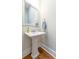 Charming powder room with a pedestal sink, framed mirror, and hardwood floors at 1464 Stratton Pl, Mount Pleasant, SC 29466