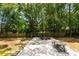 Expansive backyard with mature trees and a large patio with comfortable seating, perfect for outdoor entertaining at 1515 N Lakeshore Dr, Mount Pleasant, SC 29466
