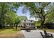 Spacious backyard with patio, dining area and mature trees creating a serene outdoor living space at 1515 N Lakeshore Dr, Mount Pleasant, SC 29466