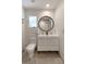 Modern bathroom features a vanity sink, toilet, a round mirror and shiplap accent wall at 1515 N Lakeshore Dr, Mount Pleasant, SC 29466